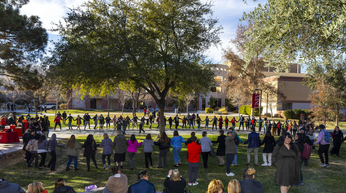 Attendees hold hands as they take part in a round dance about the amphitheater during an Intert ...