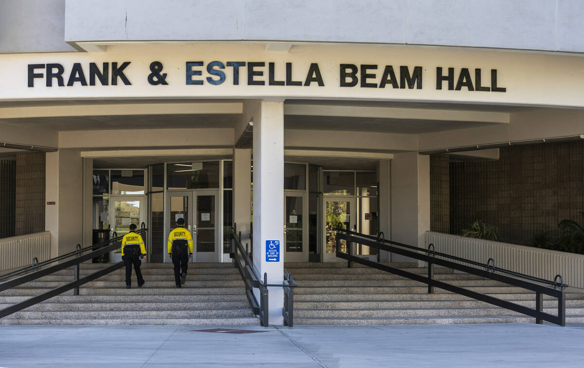 Security personnel walk into the Frank & Estella Beam Hall which is currently closed to stu ...