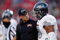Former UNLV coach Marcus Arroyo listens to OL Amani Trigg-Wright during a game against New Mexi ...