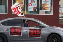 FILE - Fast-food workers drive though a McDonald's restaurant demanding a $15 hourly minimum wa ...