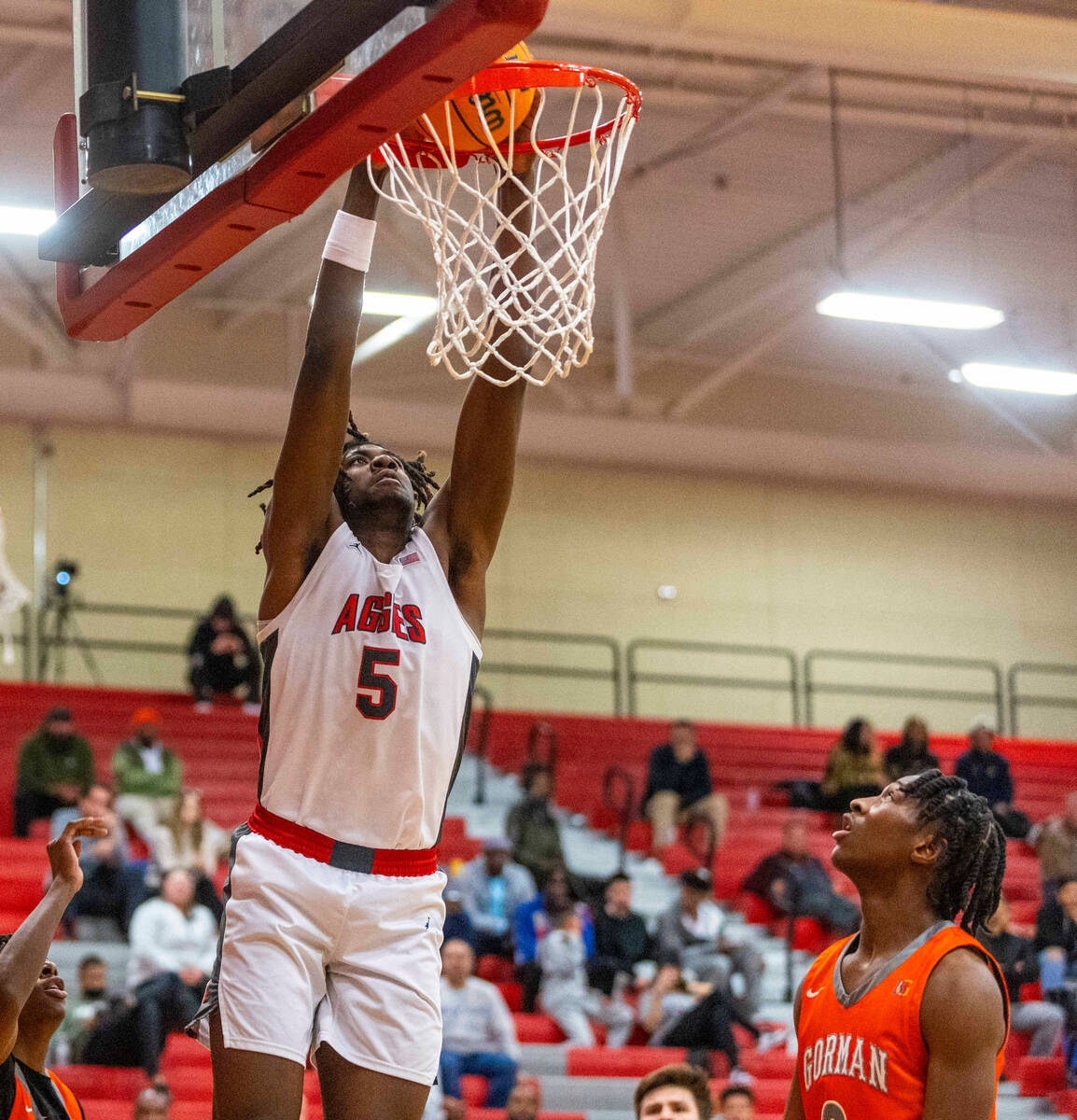 Arbor View forward Pharaoh Compton (5) dunks as Bishop Gorman forward Jett Washington (2) looks ...