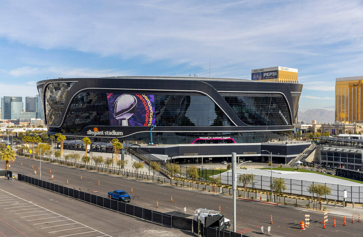 A Super Bowl banner is applied to Allegiant Stadium as preparations continue on Wednesday, Jan. ...