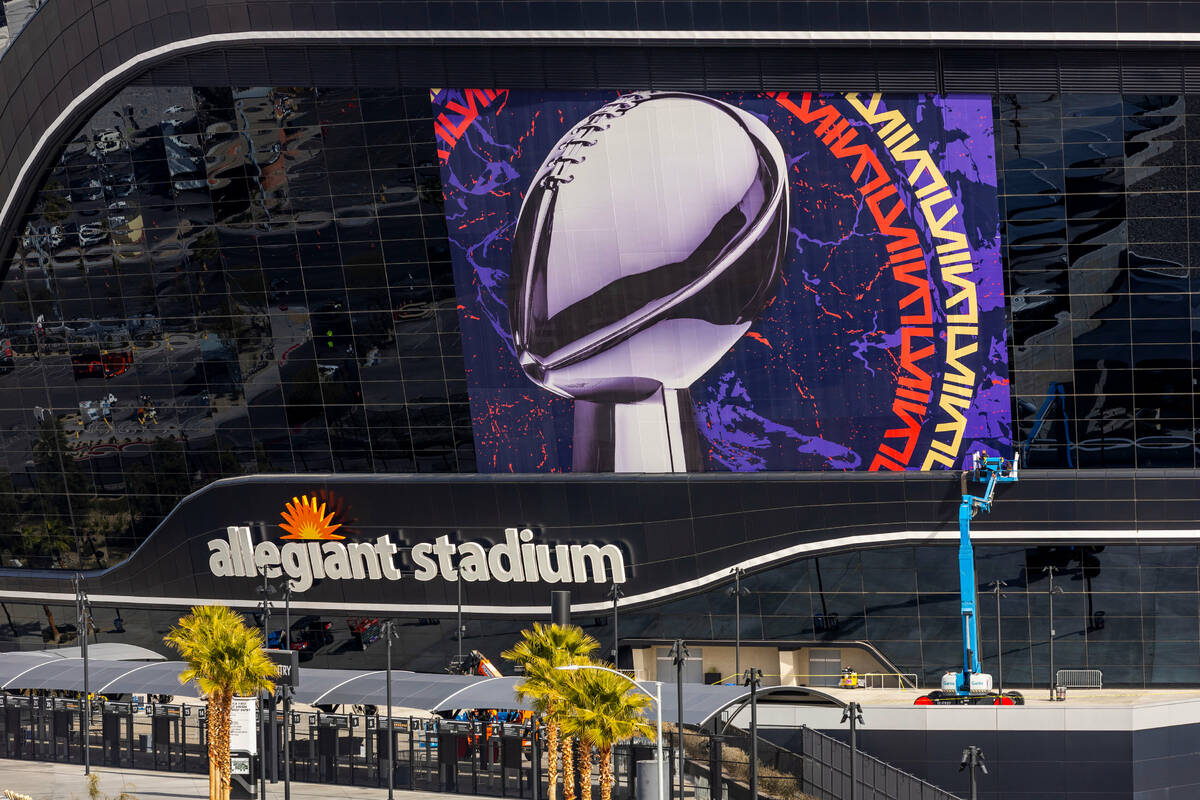 A Super Bowl banner is applied to Allegiant Stadium as preparations continue on Wednesday, Jan. ...