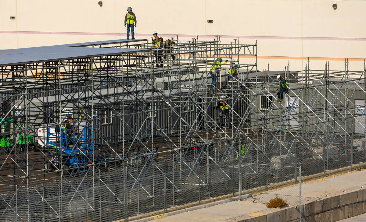A construction crew assembles a riser across from Allegiant Stadium as Super Bowl preparations ...