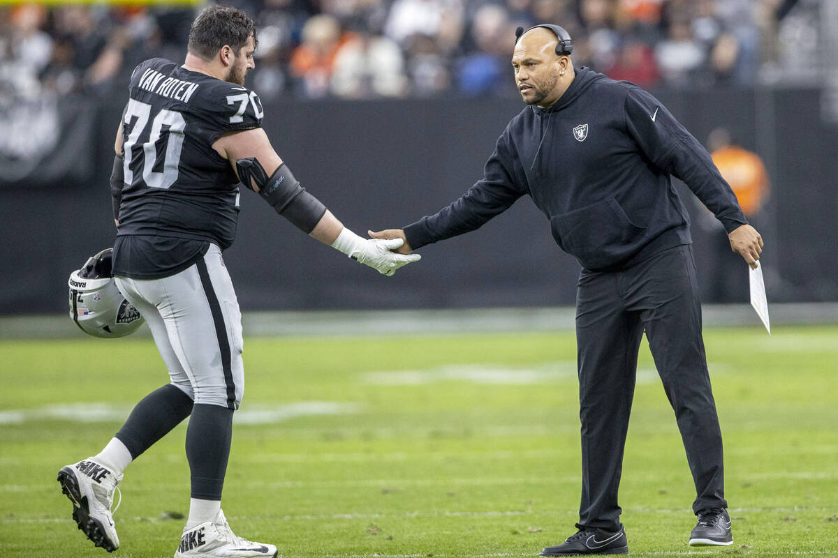Raiders interim head coach Antonio Pierce congratulates Raiders guard Greg Van Roten (70) after ...