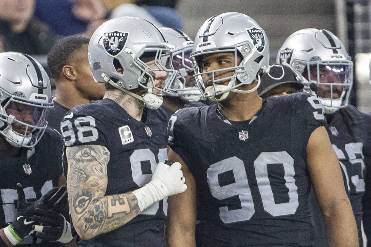 Raiders defensive end Maxx Crosby (98) and Raiders defensive tackle Jerry Tillery (90) have a c ...