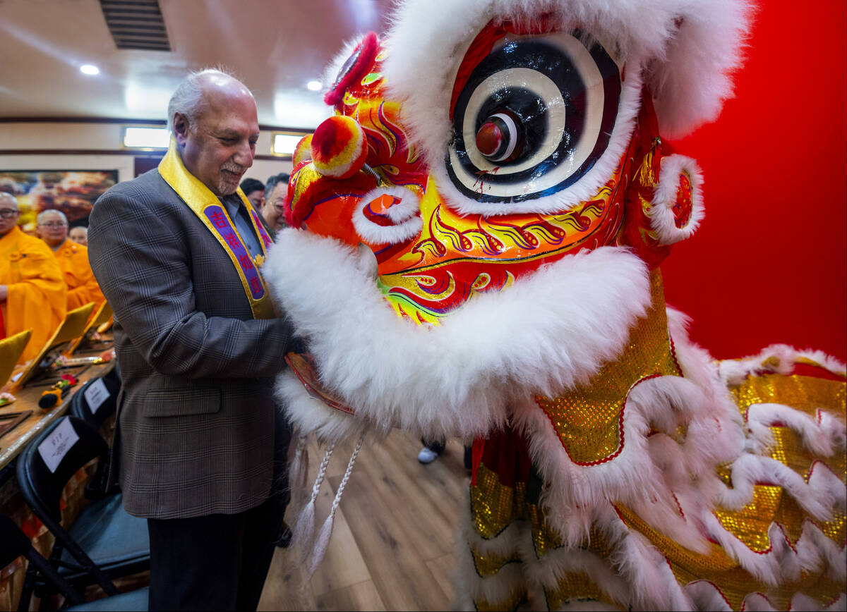 Nevada Lieutenant Governor Stavros Anthony feeds a red pocket filled with money to the lion for ...