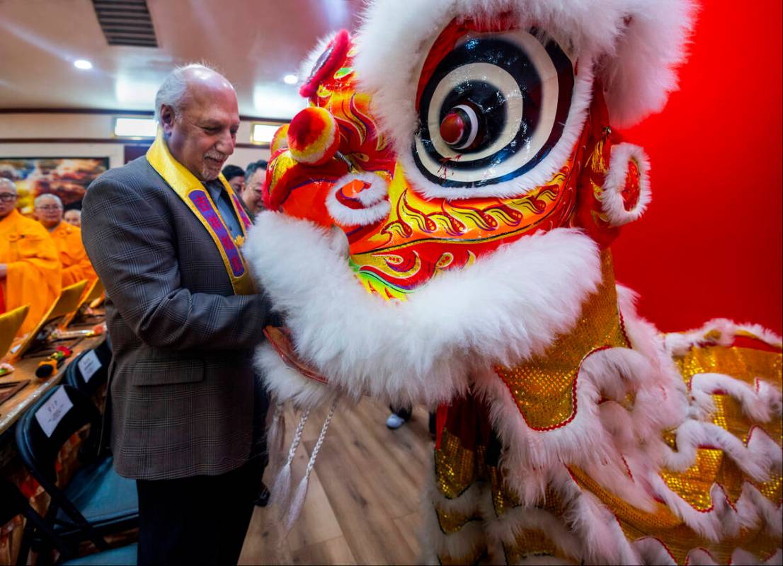Nevada Lieutenant Governor Stavros Anthony feeds a red pocket filled with money to the lion for ...