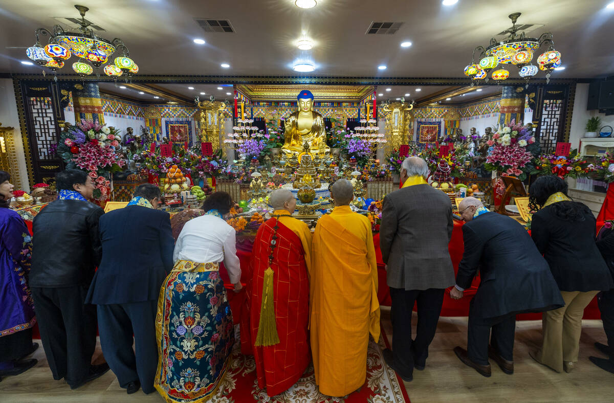 Holy Guru Zhengda Jiaozun, center, joins invited dignitaries in lowering a curtain to reveal th ...