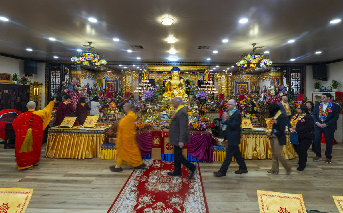 Holy Guru Zhengda Jiaozun, center left, sprinkles blessed water while joined by invited dignita ...