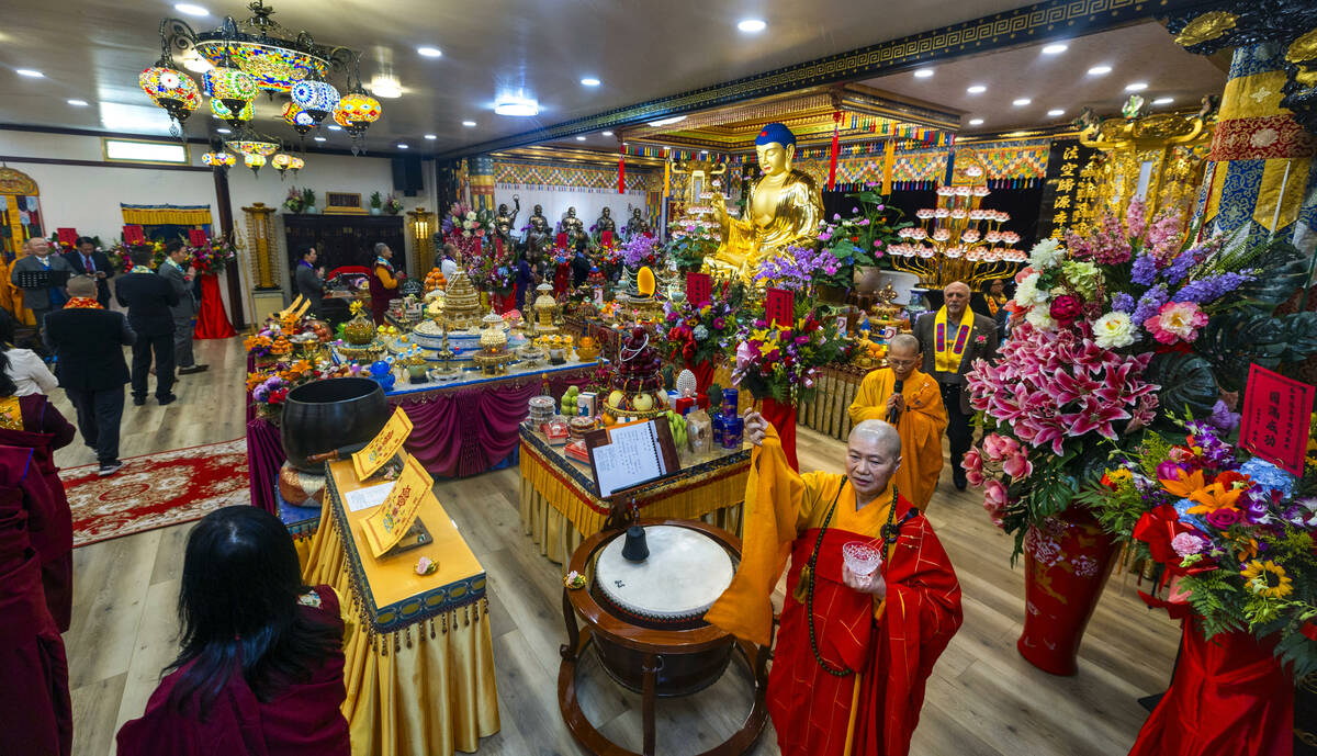 Holy Guru Zhengda Jiaozun, center, sprinkles blessed water while joined by invited dignitaries ...