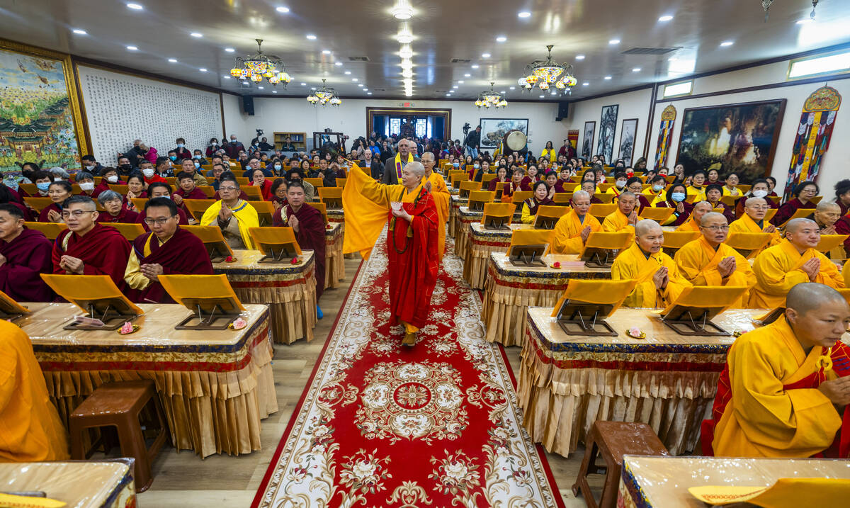 Holy Guru Zhengda Jiaozun sprinkles blessed water on attendees while walking up the aisle durin ...