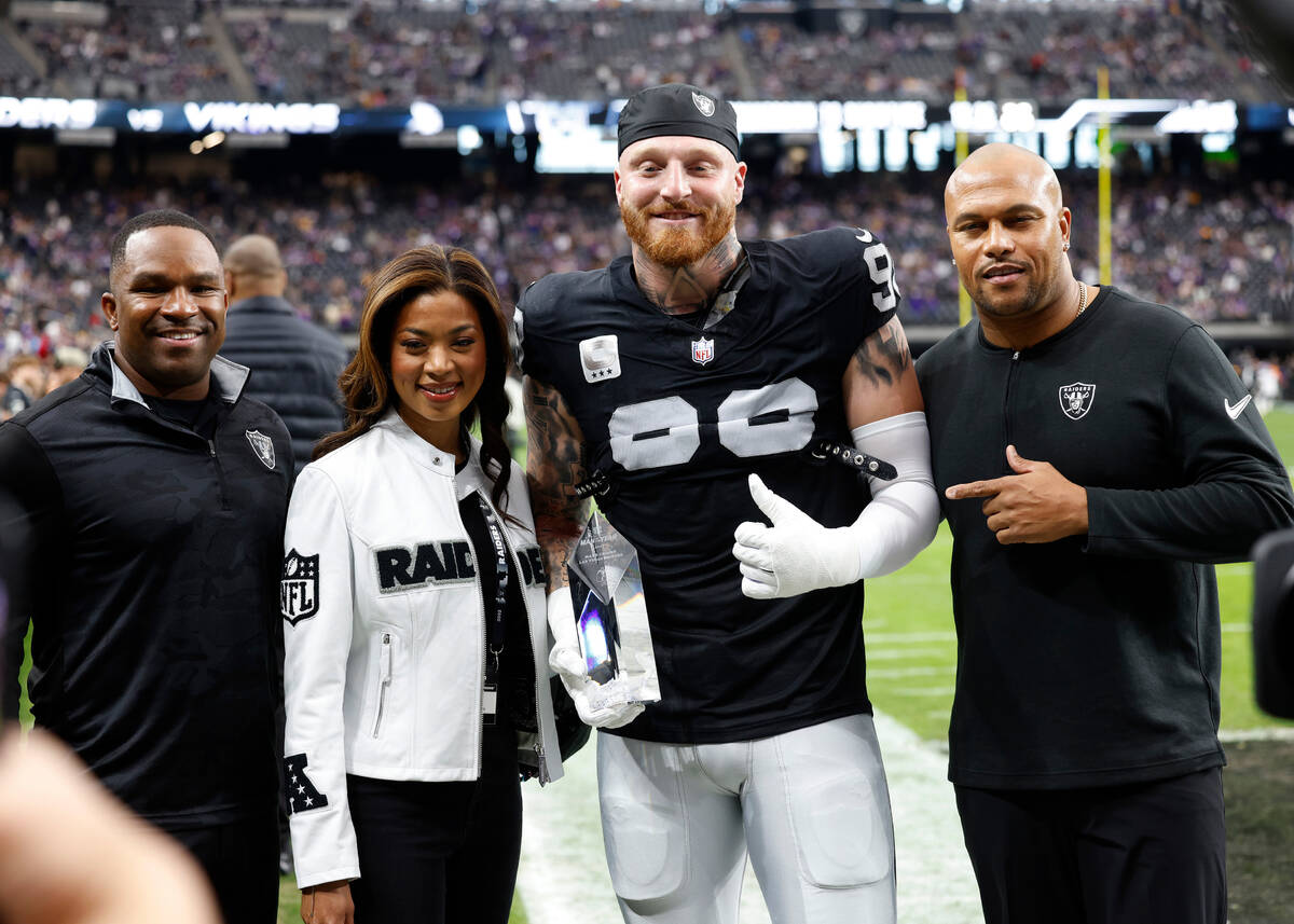 Raiders defensive end Maxx Crosby (98) poses for a photo with General Manager Champ Kelly, left ...