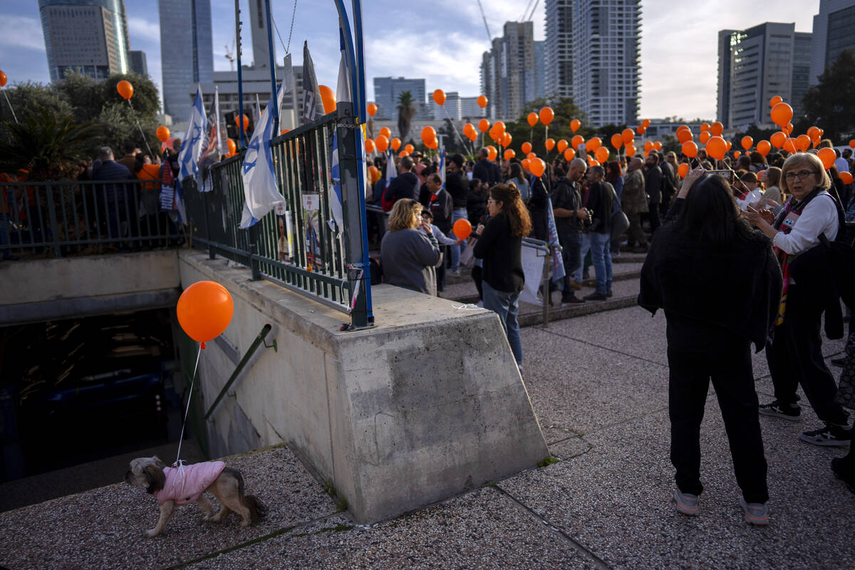 Demonstrators hold orange balloons at a rally in solidarity with Kfir Bibas, an Israeli boy who ...