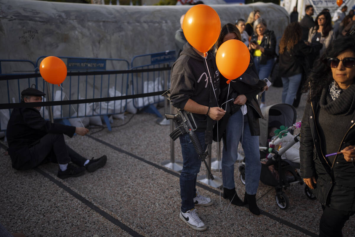 Demonstrators hold orange balloons at a rally in solidarity with Kfir Bibas, an Israeli boy who ...