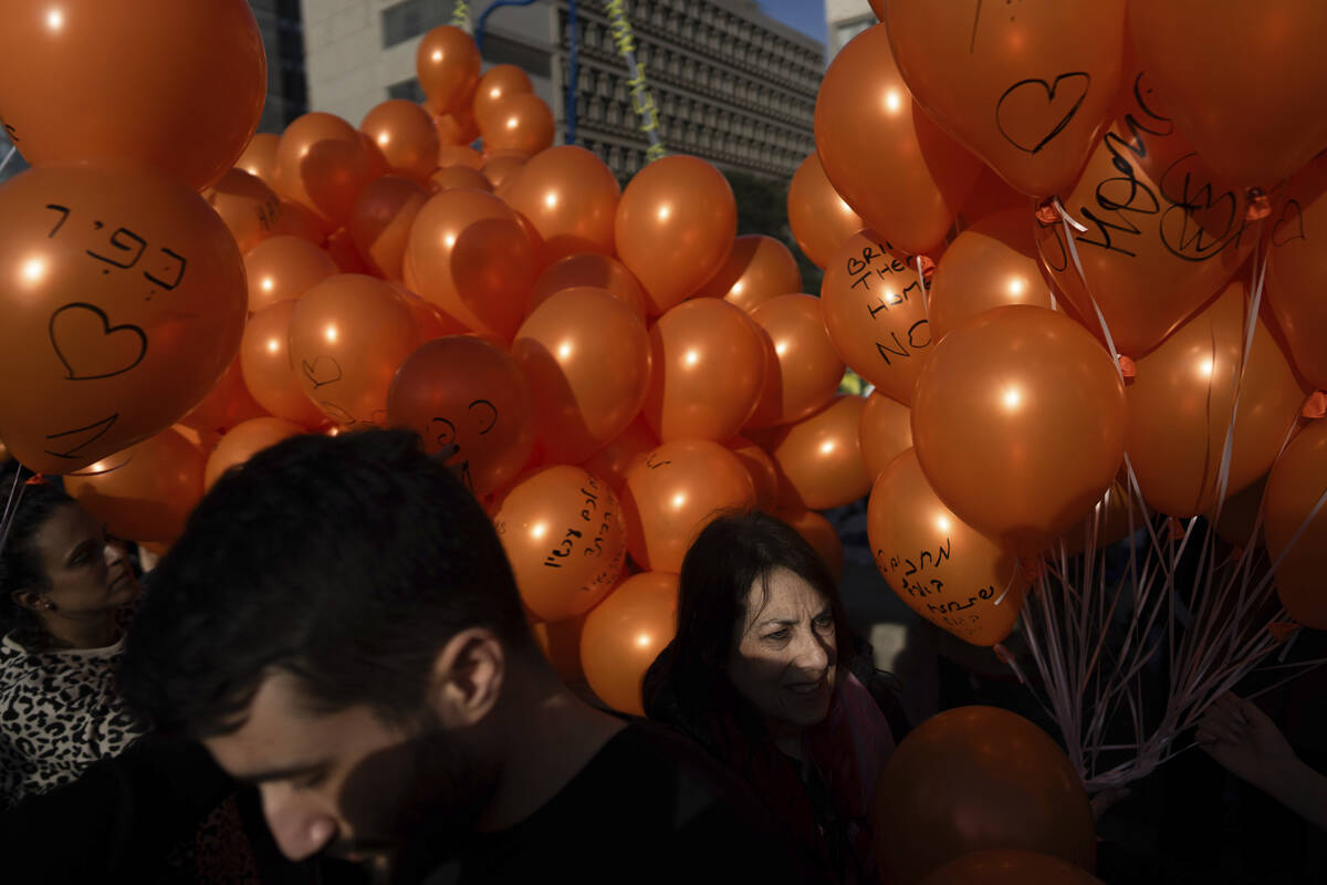 Demonstrators hold orange balloons at a rally in solidarity with Kfir Bibas, an Israeli boy who ...