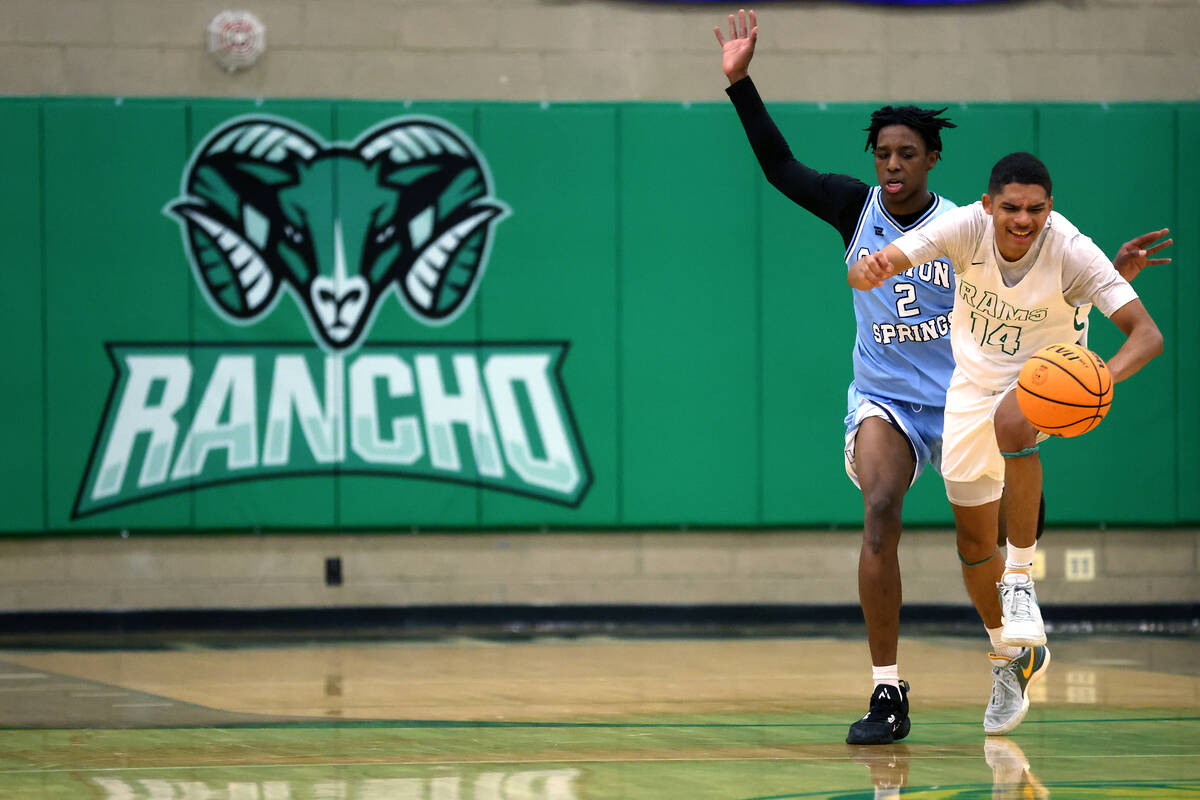 Rancho guard Caleb Roston (14) drives up the court against Canyon Springs guard Melvin Reece (2 ...