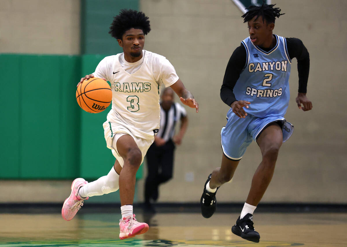 Rancho guard Jordan Childress (3) drives up the court against Canyon Springs guard Melvin Reece ...