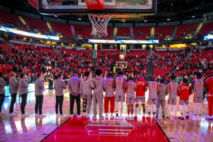 UNLV players and coaches stand for the national anthem to face the Utah State Aggies during the ...