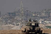Israeli soldiers overlook the Gaza Strip from a tank, as seen from southern Israel, Friday, Jan ...