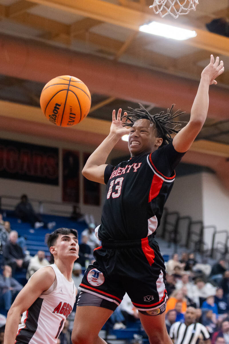 Liberty’s Jaden Riley (13) goes in for the rebound during a basketball game between Arbo ...