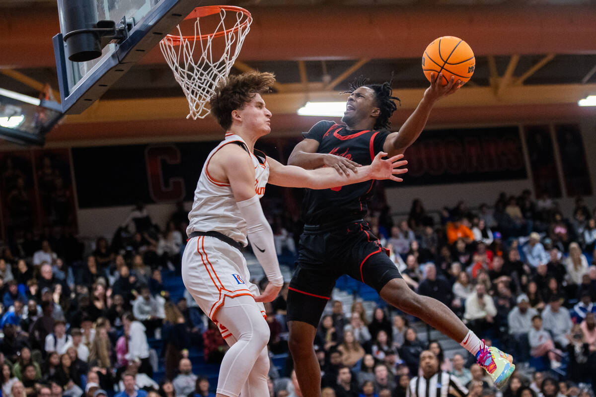 Coronado’s Josiah Cunningham (23) goes in for a layup around Bishop Gorman’s Noah ...