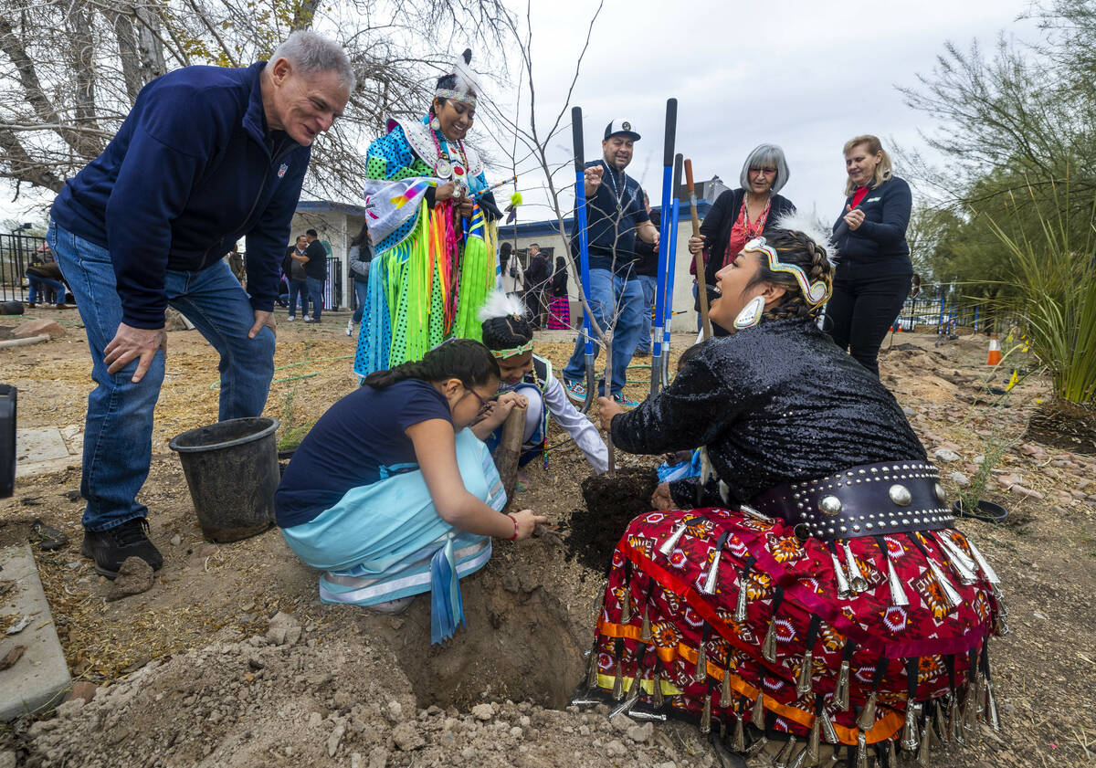 Attendees plant a ceremonial tree during the first of Super Bowl "Green Week" events ...