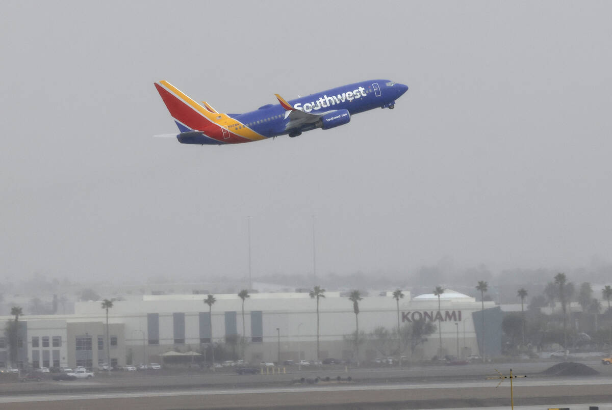 Fog lingers over Harry Reid International Airport as the Southwest Airways plane takes off, on ...