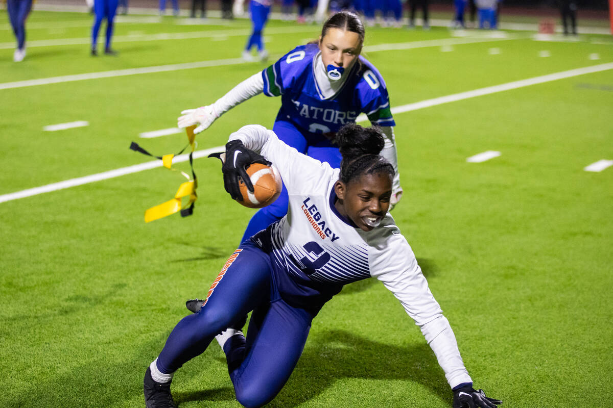 Green Valley’s Kaylee Montalvo (0) pulls the flag off of Legacy’s Mailaya Taylor ...