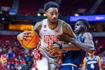 UNLV forward Kalib Boone (10) is held by Utah State Aggies forward Kalifa Sakho (34) during the ...