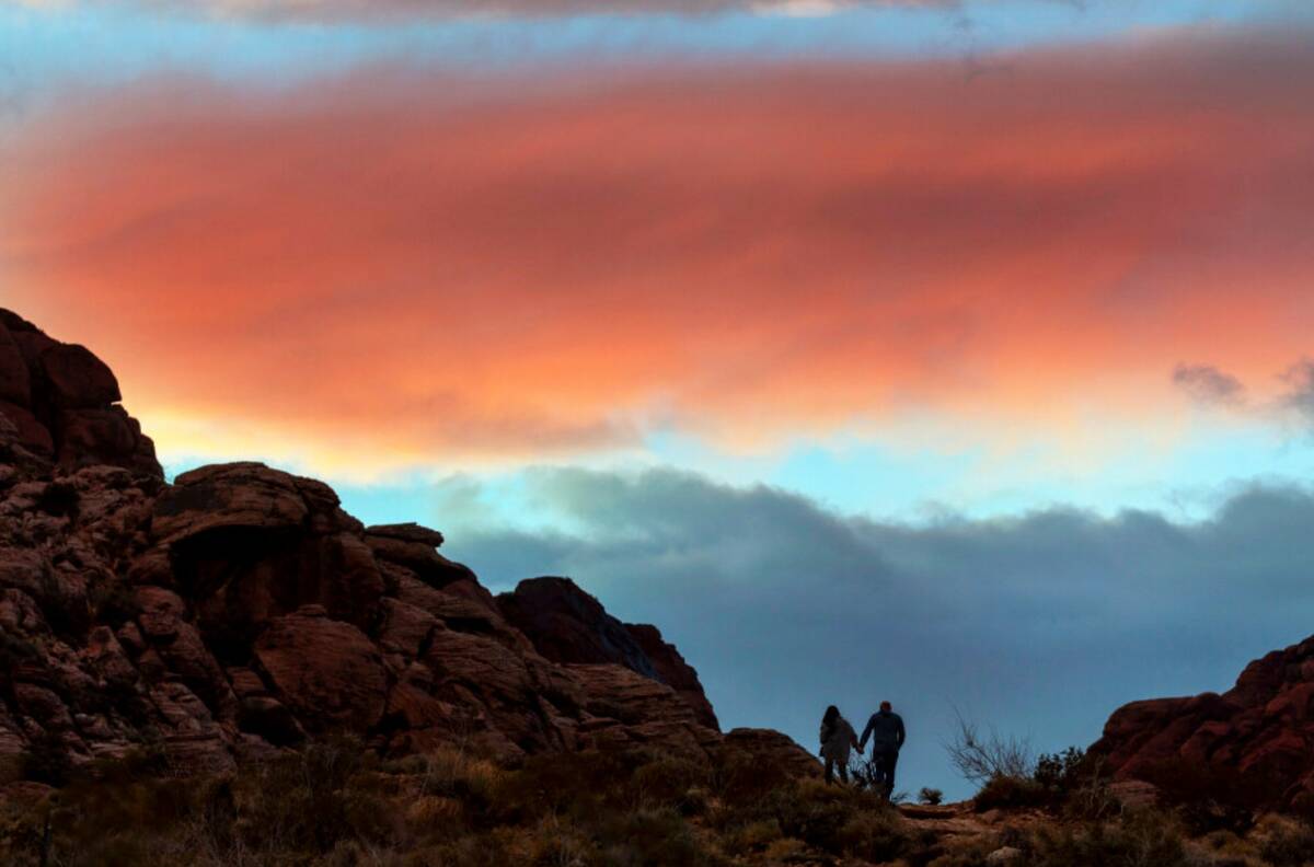 A couple walks up a path in the sunset at Red Springs within the Red Rock Canyon National Conse ...
