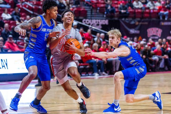 UNLV guard Dedan Thomas Jr. (11) drives past Air Force Falcons forward Chase Beasley (13) while ...