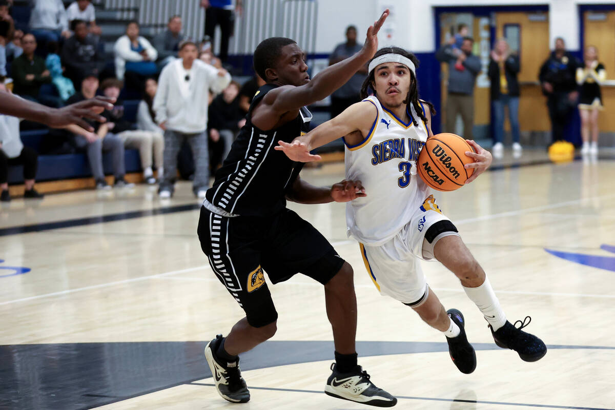 Sierra Vista guard Khamari Taylor (3) drives toward the hoop against Clark guard Brenden Banks- ...