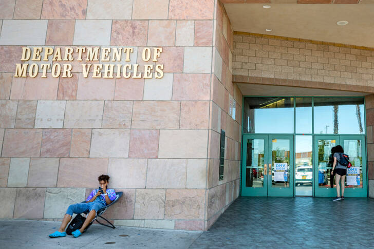 Individuals wait outside the Nevada Department of Motor Vehicles office on American Pacific Dri ...