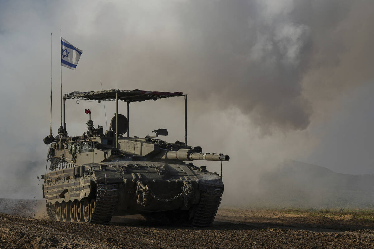 An Israeli army tank moves near the Gaza Strip border, in southern Israel, Wednesday, Jan. 24, ...
