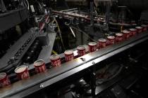 File - Coca-Cola cans move down a conveyer belt in the Swire Coca-Cola bottling plant on Oct. 2 ...