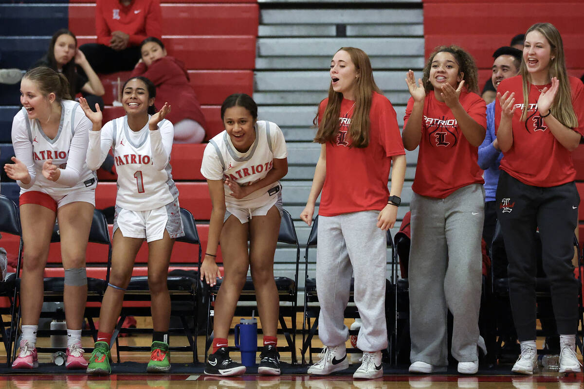 The Liberty bench cheers for their team during the second half of a high school basketball game ...