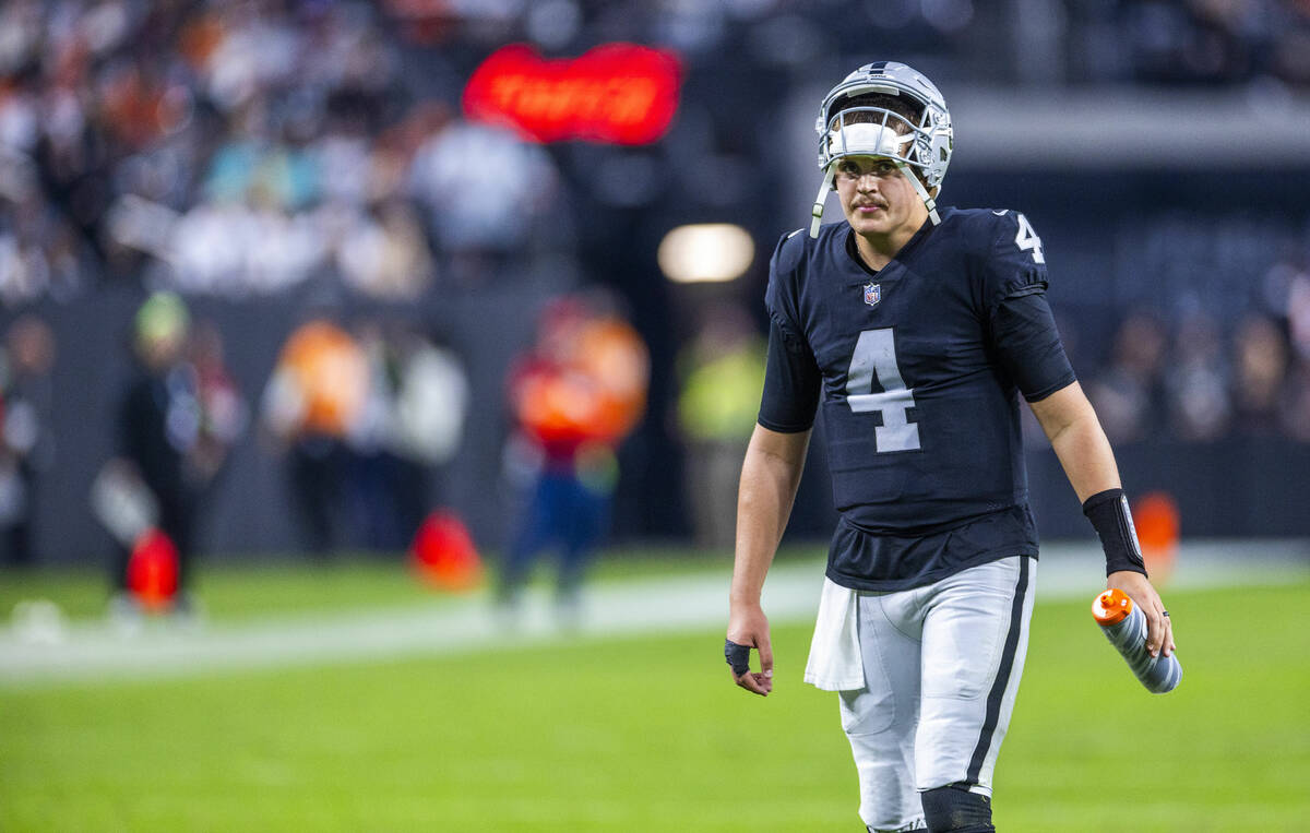 Raiders quarterback Aidan O'Connell (4) waters up on a timeout against the Denver Broncos durin ...