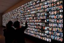 Visitors look at photos of Israeli people who were killed during Hamas militants attack on Oct. ...