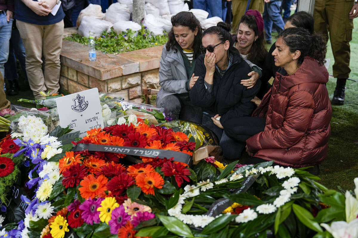 Raya, wife of Israeli reserve solider Sergeant major Eliran Yeger, mourns in grief around the g ...