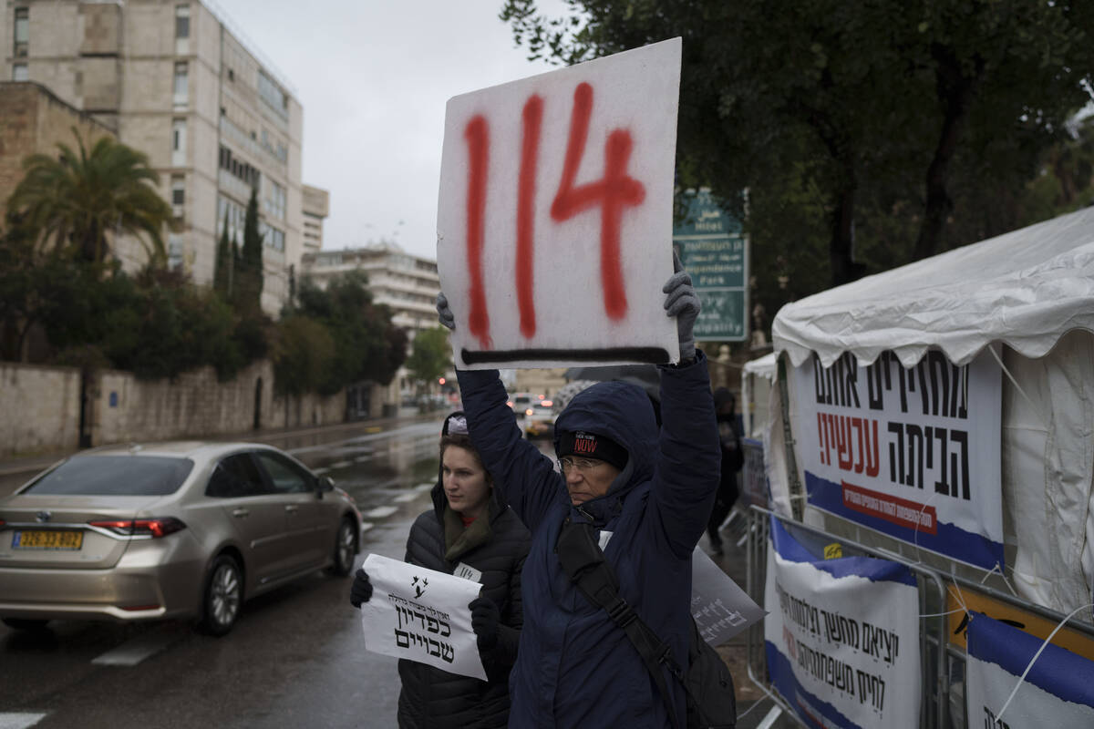 Jennifer Gamulka holds up a sign in reference to the 114 days that hostages have been held in t ...