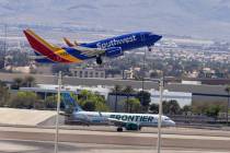 A Southwest Airlines jet takes off while a Frontier Airlines plane rolls on the tarmac at Harry ...