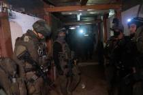Israeli soldiers stand in a Hamas tunnel underneath a cemetery during the ground offensive on t ...
