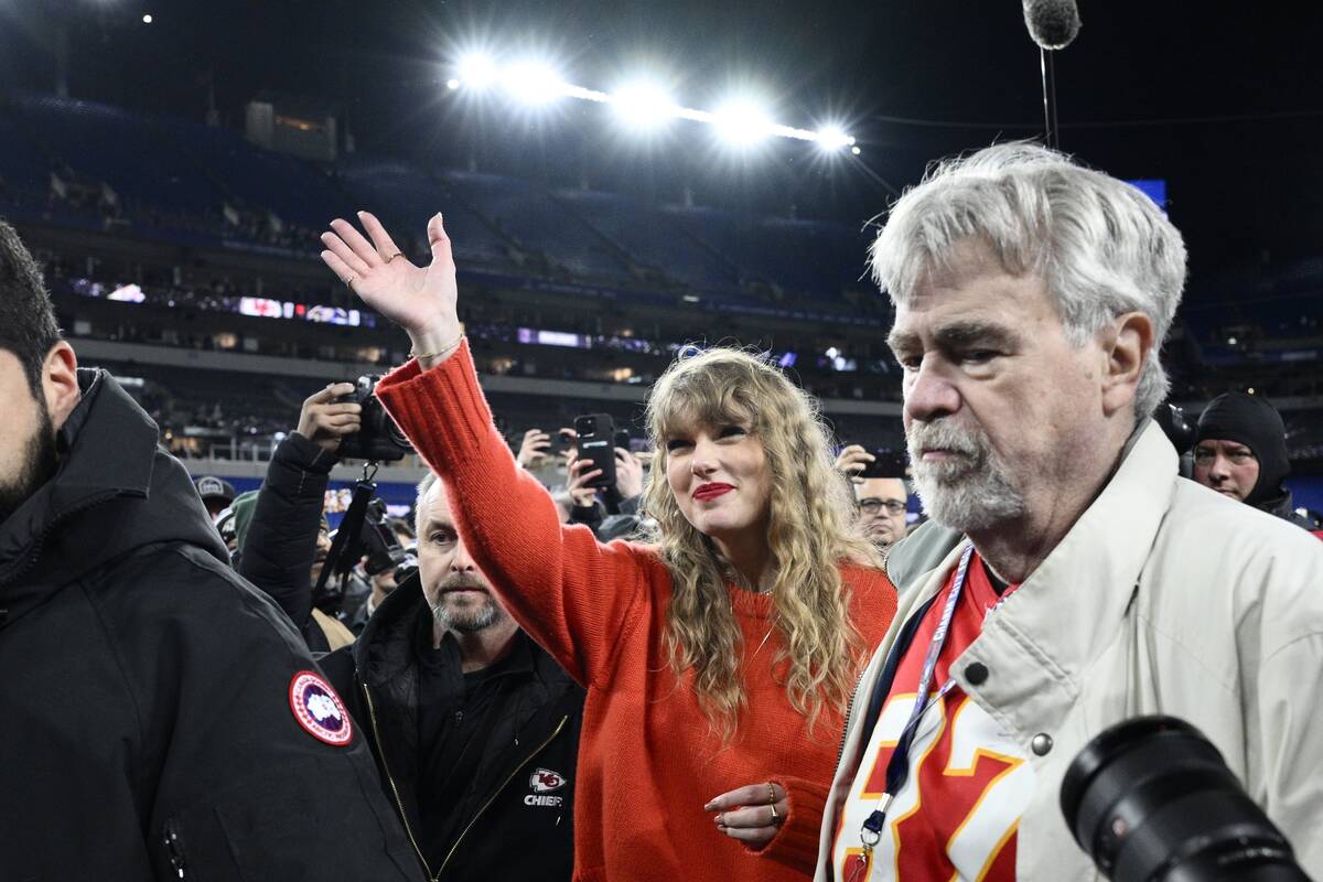 Taylor Swift waves as she walks with Ed Kelce after the AFC Championship NFL football game betw ...