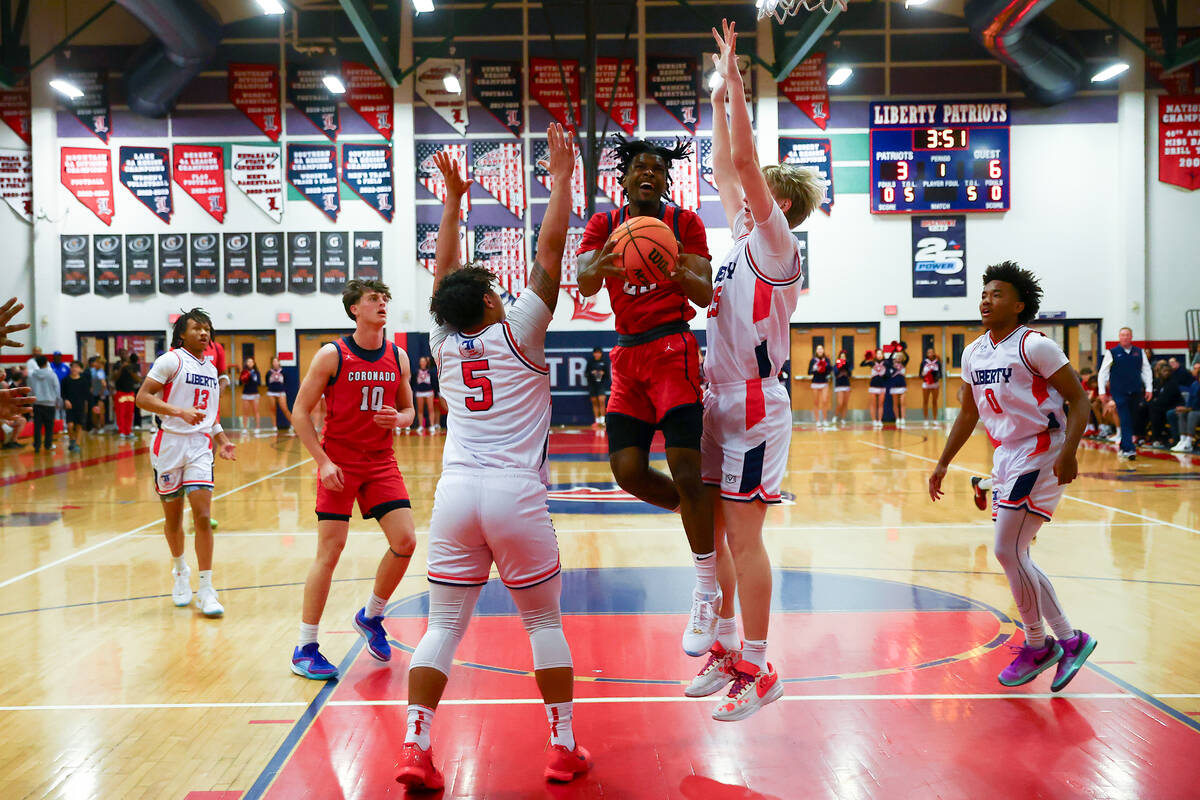 Coronado guard Josiah Cunningham (23) shoots against Liberty forward Andre Porter (5) and forwa ...