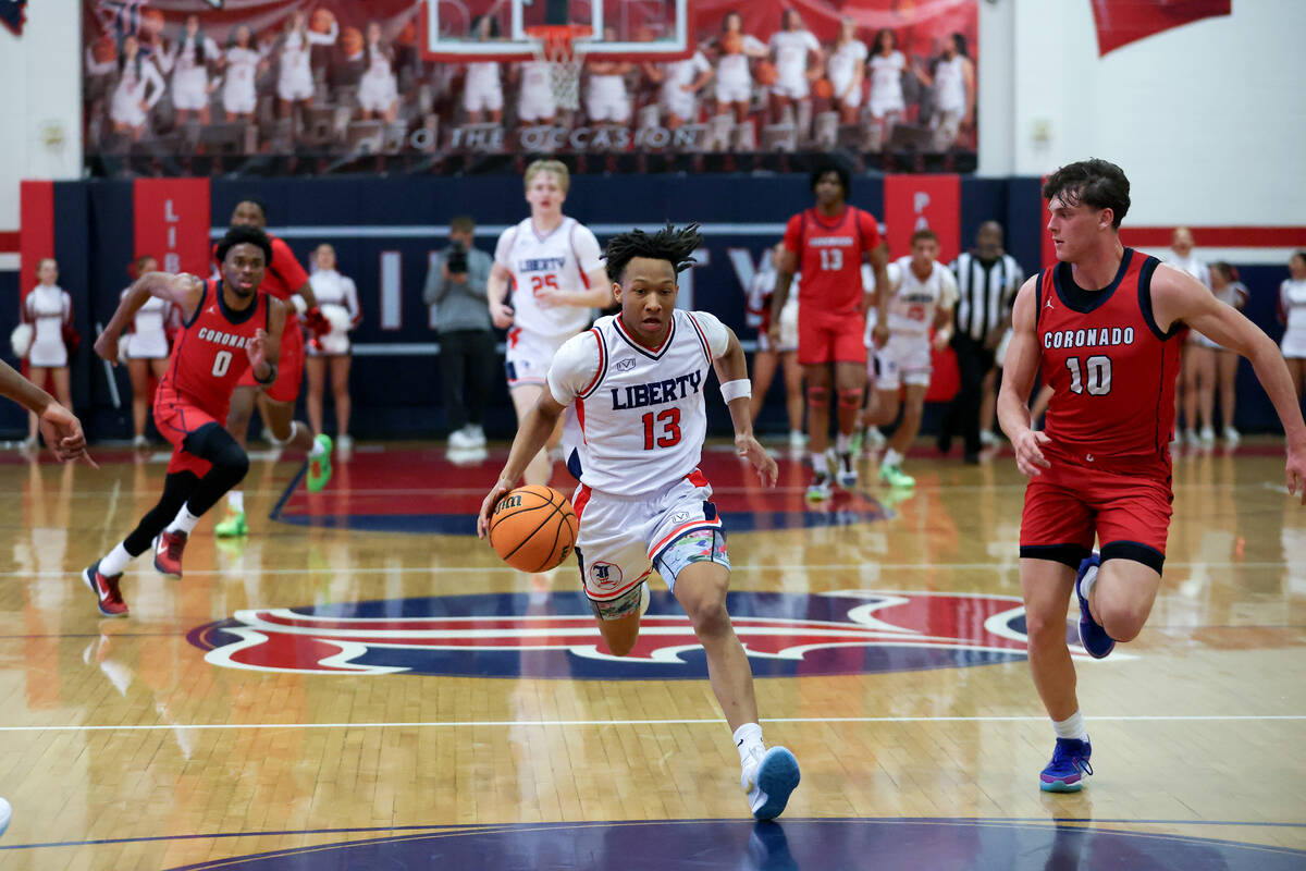 Liberty guard Jaden Riley (13) dribbles up the court against Coronado forward JJ Buchanan (10) ...