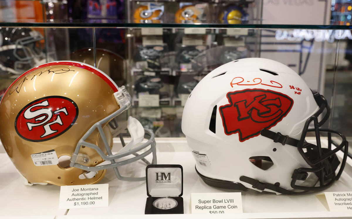Authentic Helmets signed by Joe Montana, left, and Patrick Mahomes are displayed at the NFL Las ...