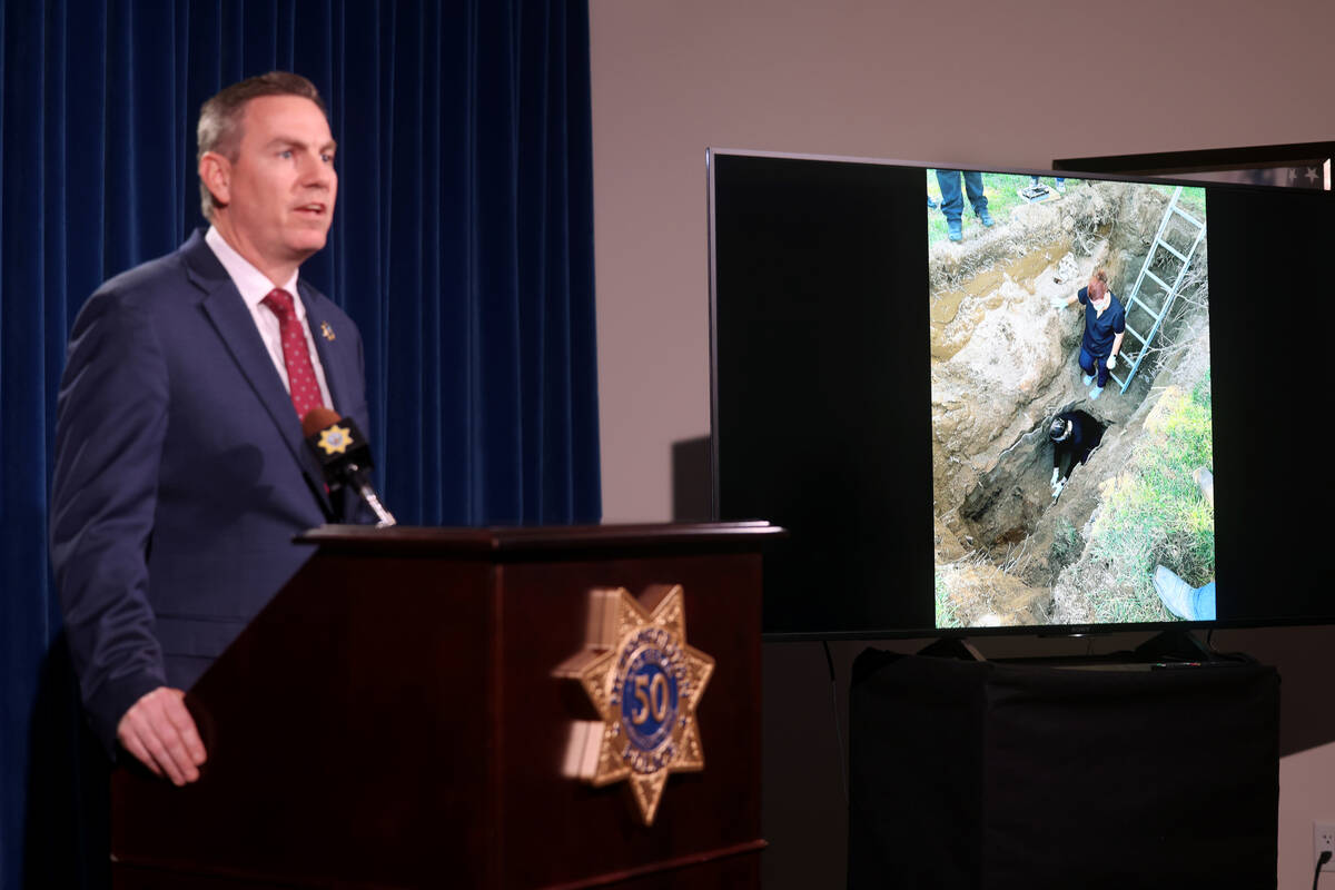Homicide Lt. Jason Johansson shows a photo of exhumation of the body of Thomas Martin Elliott, ...