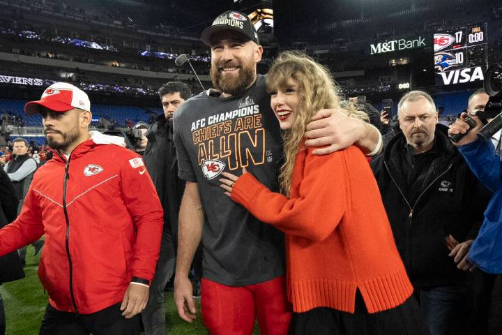 Kansas City Chiefs tight end Travis Kelce walks with Taylor Swift following the AFC Championshi ...
