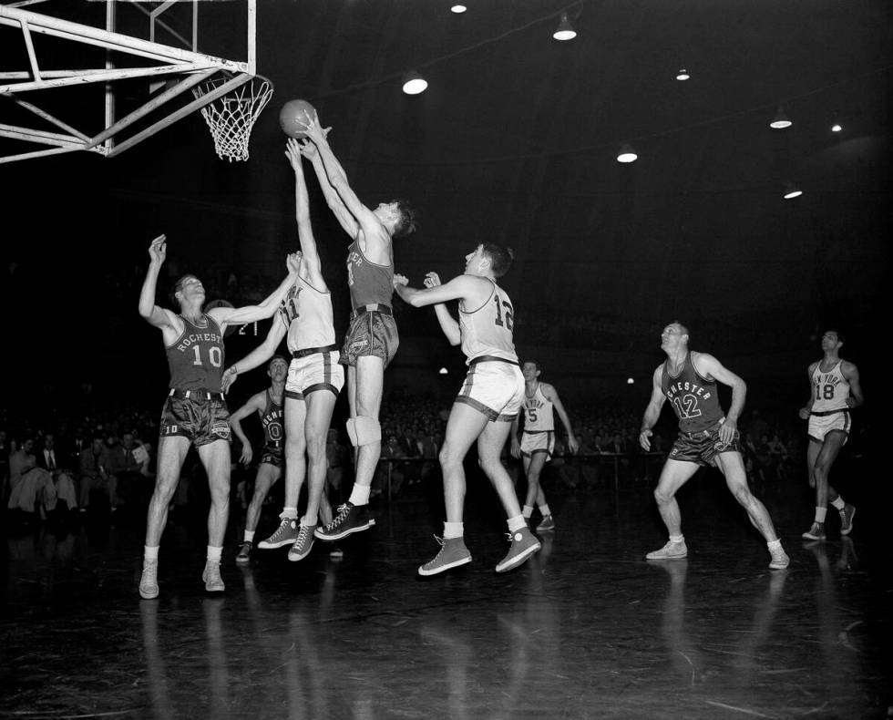 Arnie Risen, second from right, of the Rochester Royals nabs a rebound from Harry Gallatin (11) ...